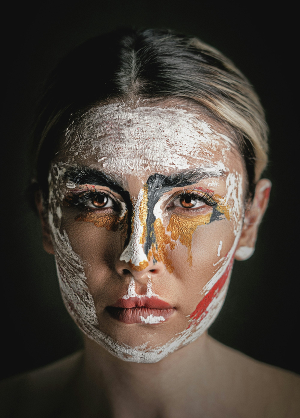 Womans face is covered in abstract paint
