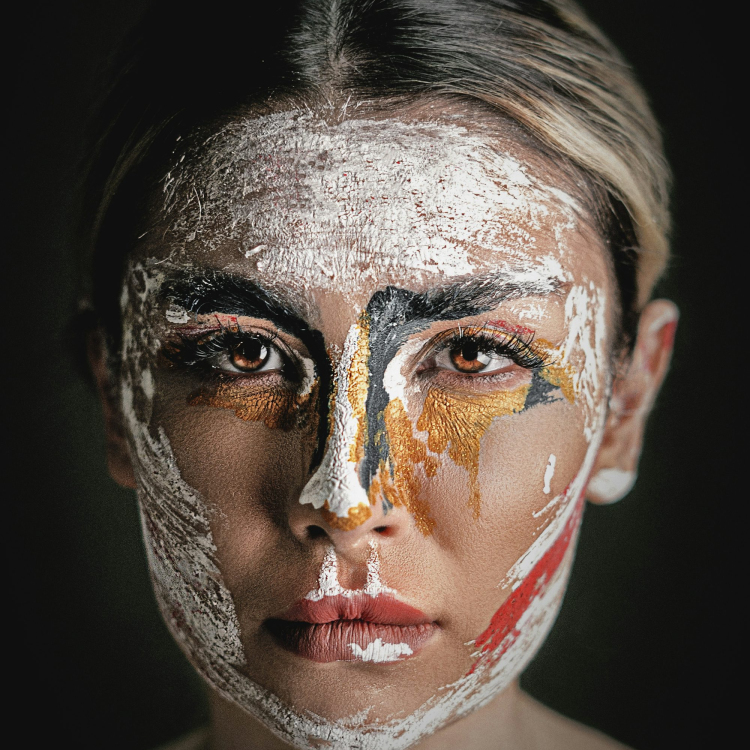 Womans face is covered in abstract paint